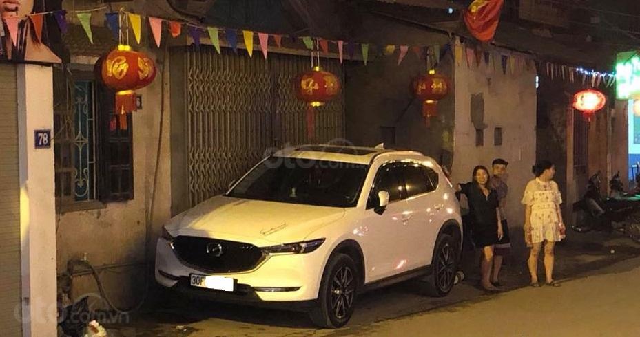 Chiếc xe Mazda CX5 đỗ chắn kín cửa nhà khiến chủ căn nhà không thể vào bên trong...